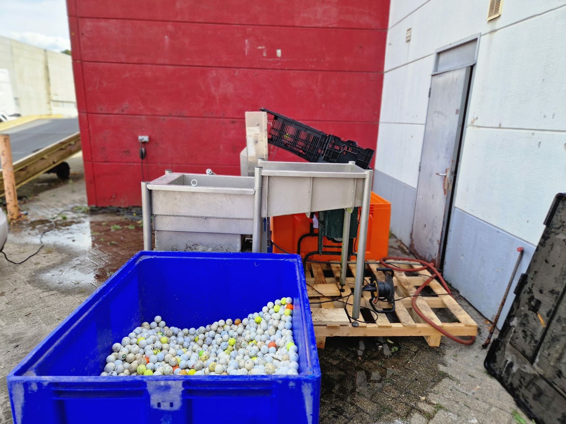 vieze golfballen liggen klaar om de schoonmaakmachine in te gaan